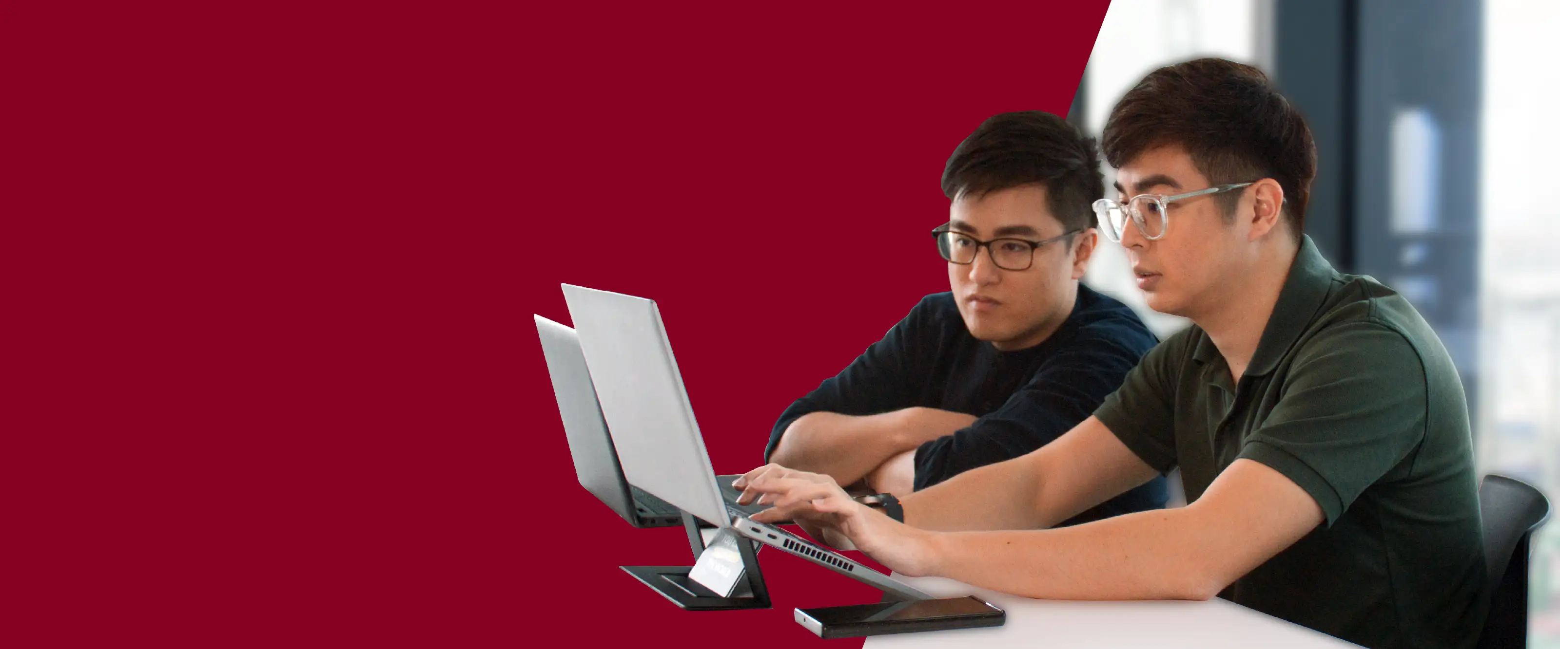 Two students co-work on a laptop.