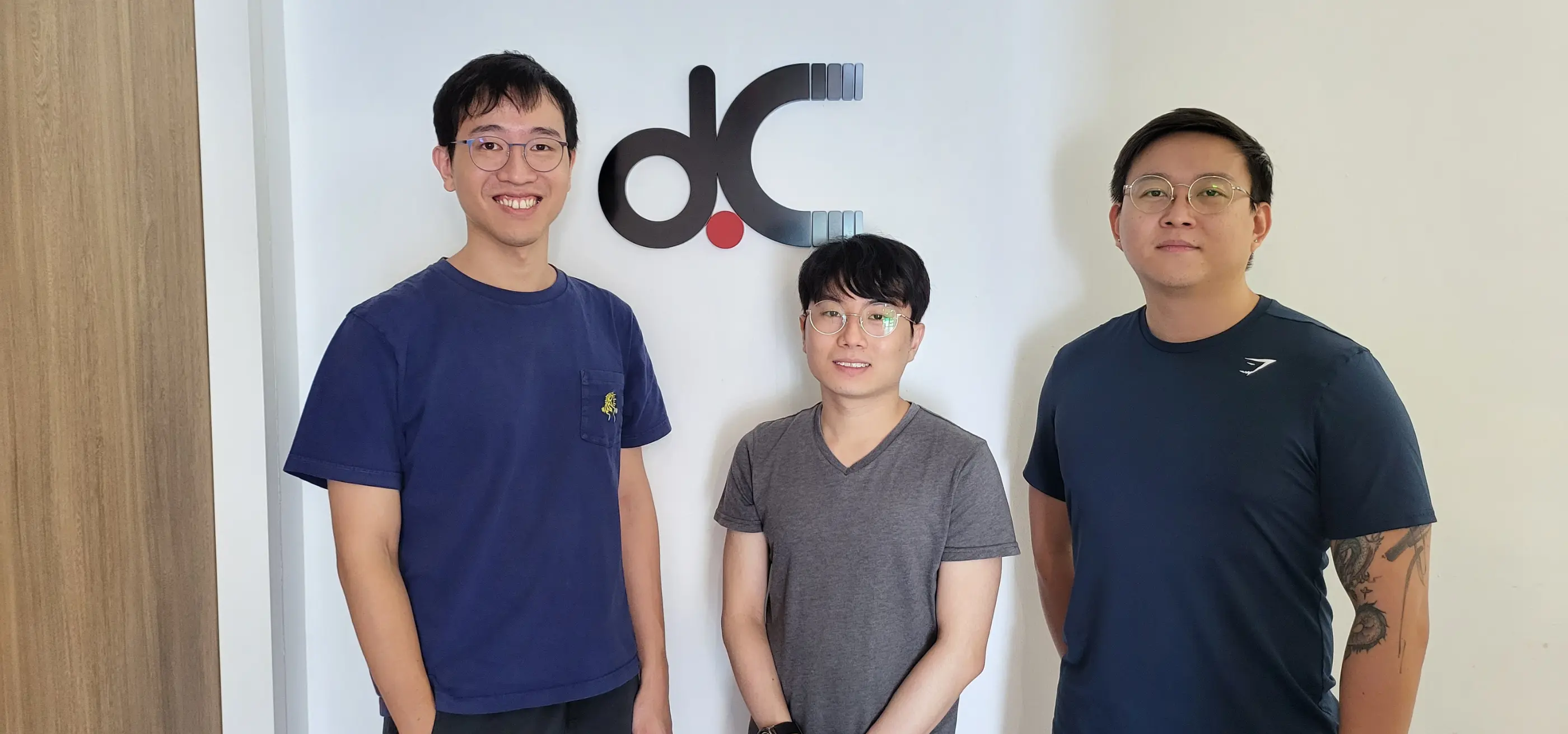 DigiPen (Singapore) graduates stand side-by-side in front of a dConstruct Robotics logo.